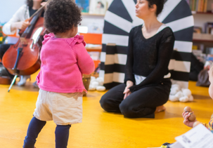 Séance d'À Tout-Petits Sons à la médiathèque des Couronneries : une petite fille regarde la danseuse et la musicienne.